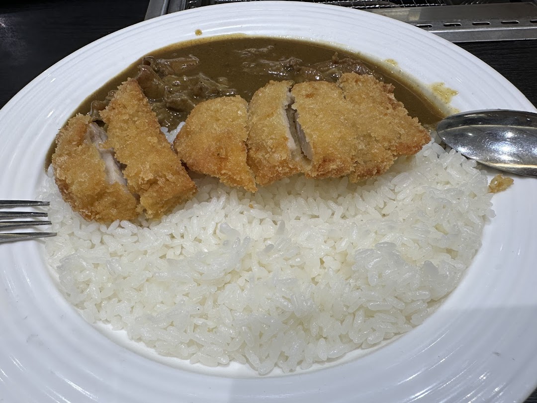 A close-up of a delicious katsu curry dish with crispy fried cutlet, rich curry, and fluffy rice.