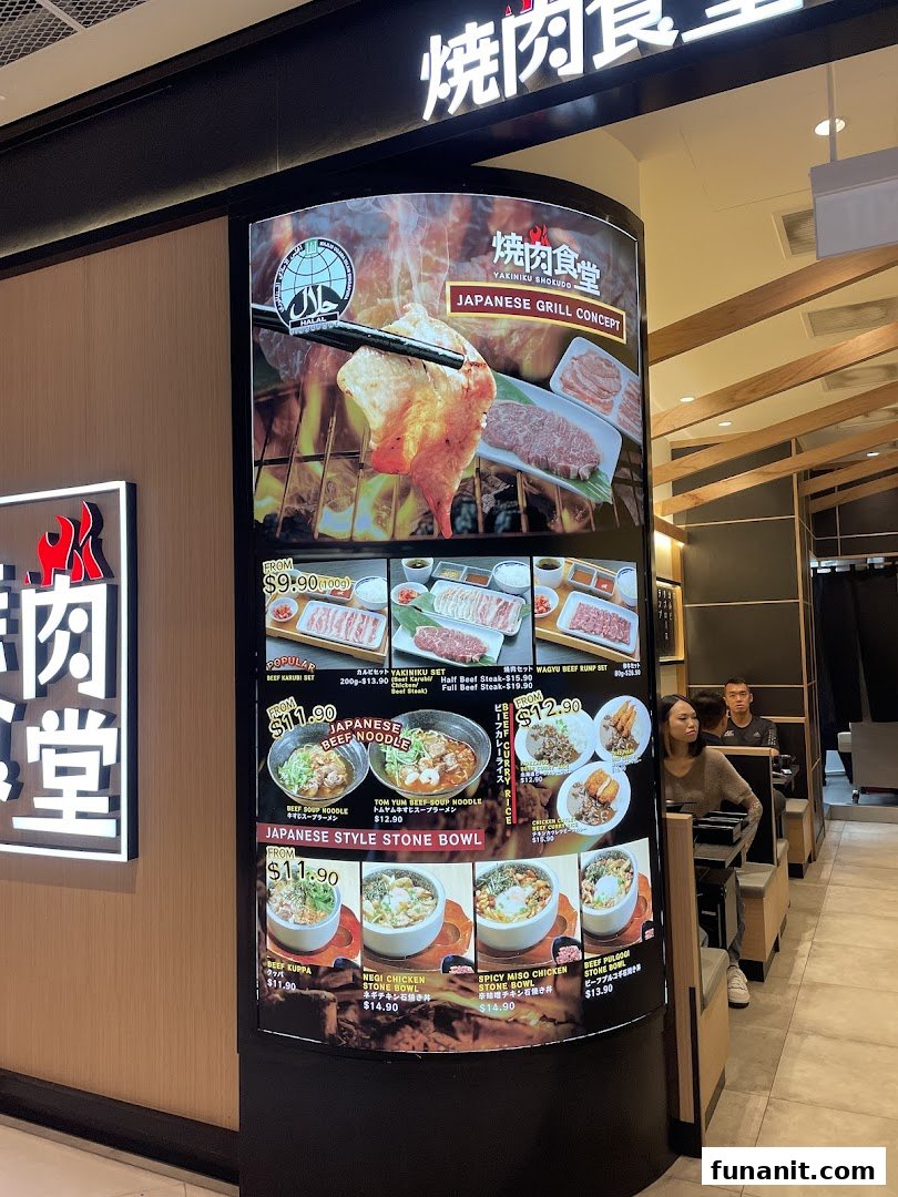 A large digital menu display for Yakiniku Shokudo, showcasing various Japanese grill and noodle dishes.