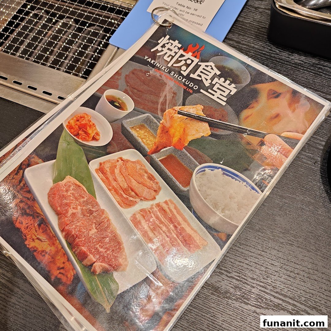 A close-up of a Yakiniku Shokudo menu cover featuring various cuts of raw meat, rice, and sauces.