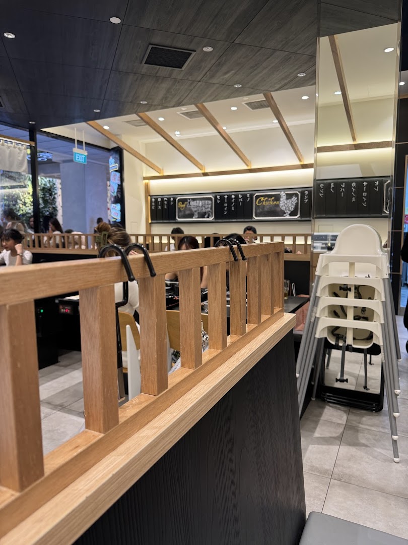 An inviting interior view of Yakiniku Shokudo, featuring dining areas, customers, and modern decor.