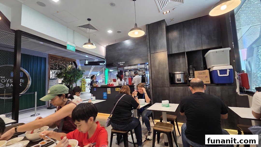 Diners enjoy a meal inside Yan Ji Gourmet Seafood Soup By GoodEarth, showcasing its casual dining atmosphere.