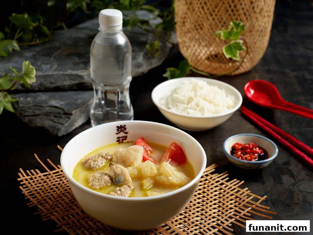 A hearty bowl of seafood soup with rice, water, and chili, ready to be enjoyed.