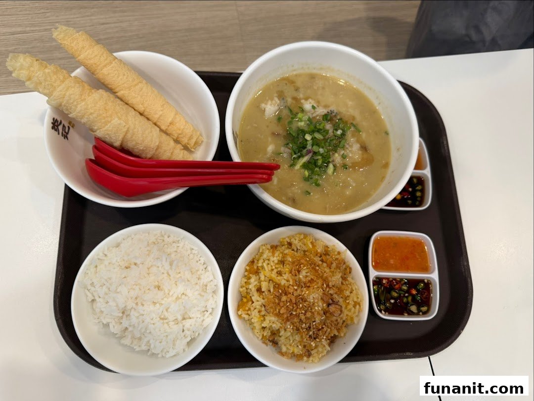 A delicious seafood soup set with rice, fried rice, crispy rolls, and various dipping sauces on a tray.