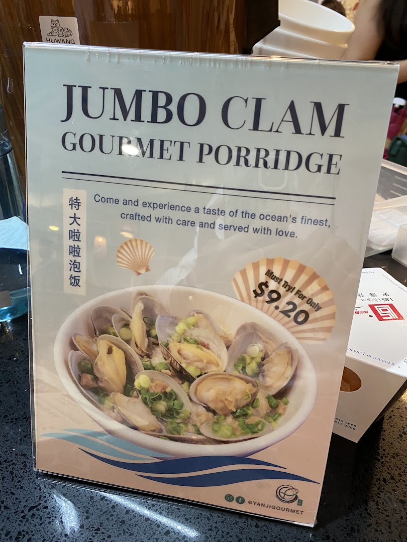 A promotional standee featuring 'Jumbo Clam Gourmet Porridge' with a price of $9.20.