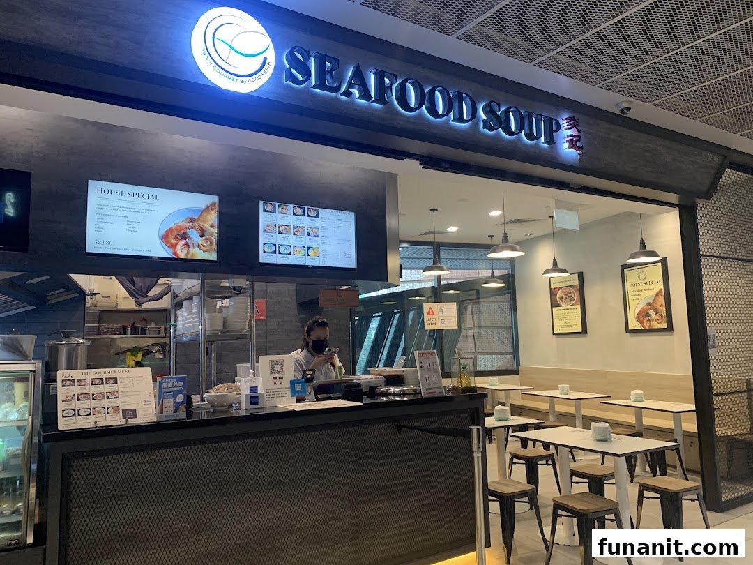 The shop front of Yan Ji Gourmet Seafood Soup, featuring its counter, digital menus, and dining area.