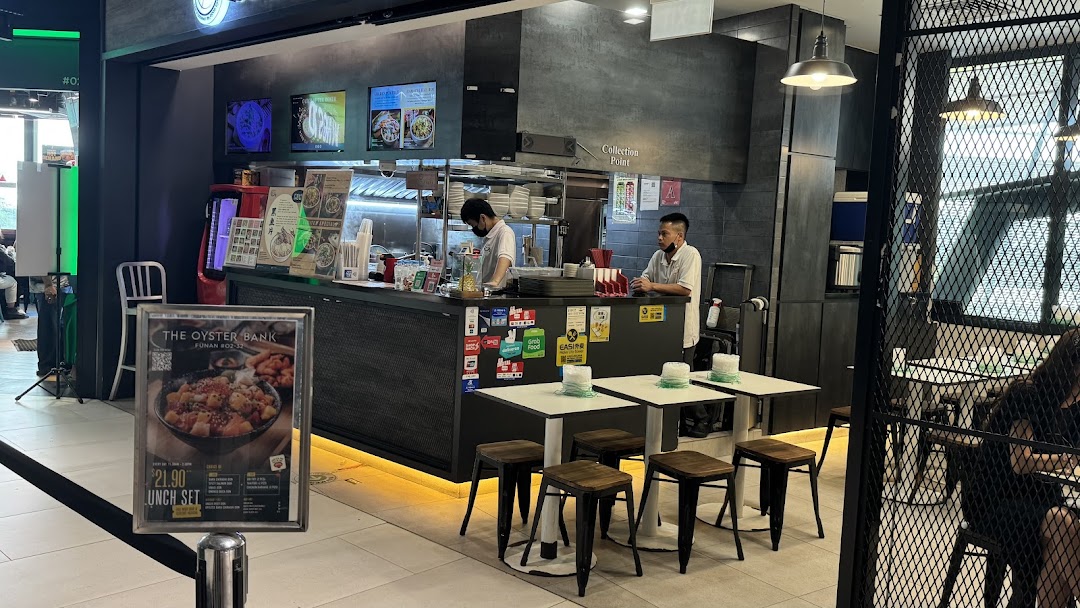 An interior view of Yan Ji Gourmet Seafood Soup, showing the counter, staff, and dining area.