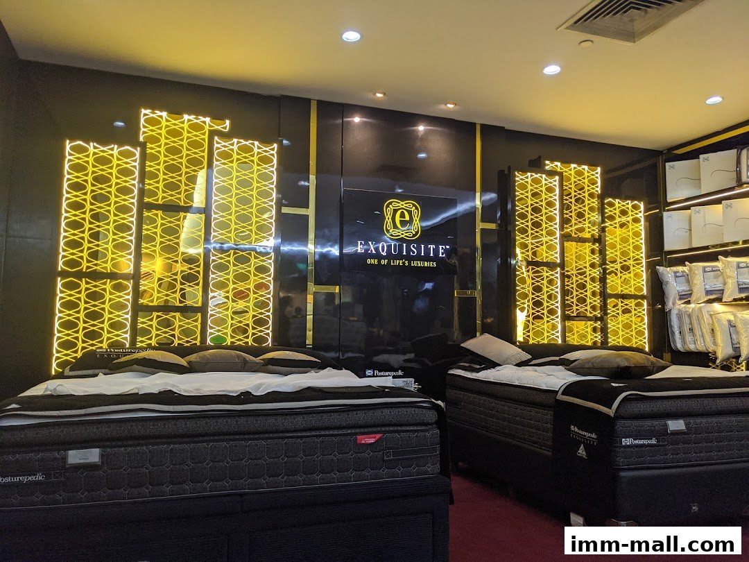 Luxurious beds displayed in a modern, well-lit sleep boutique with elegant gold accents.