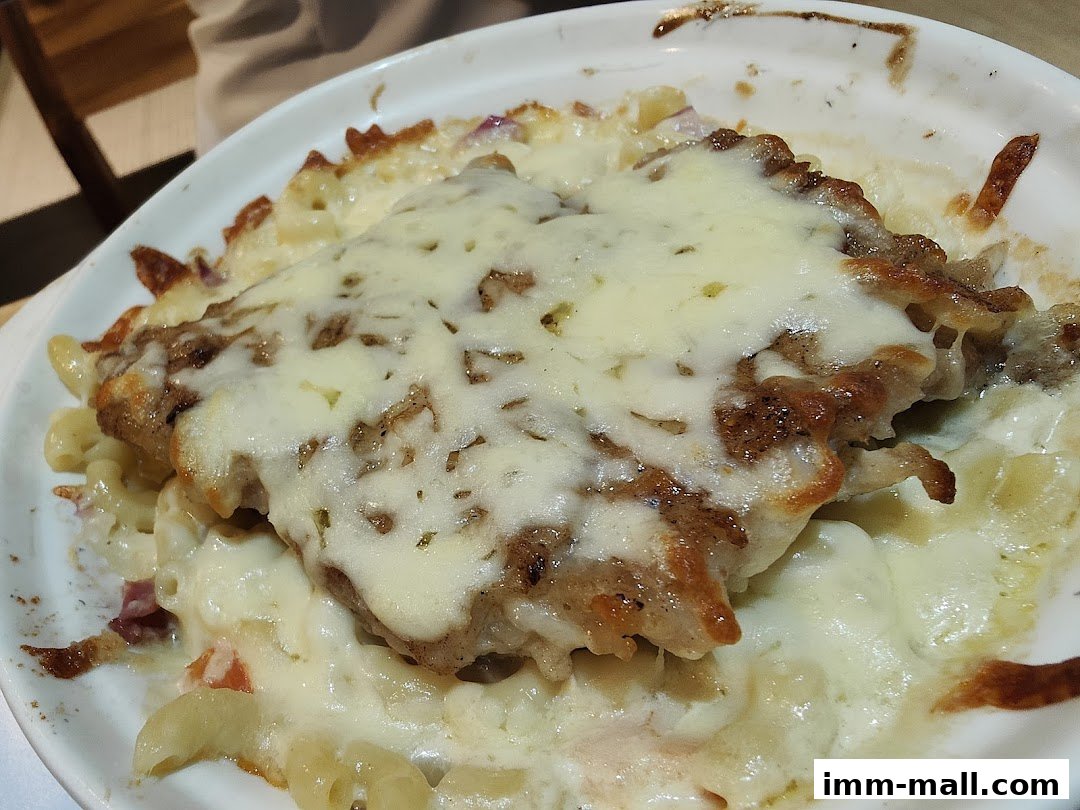 A close-up shot of a baked pasta dish topped with melted cheese and meat.