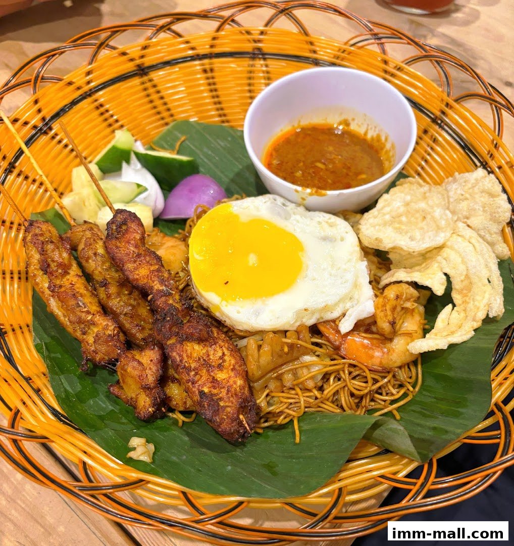 A delicious plate of noodles with satay, fried egg, prawns, and crackers.