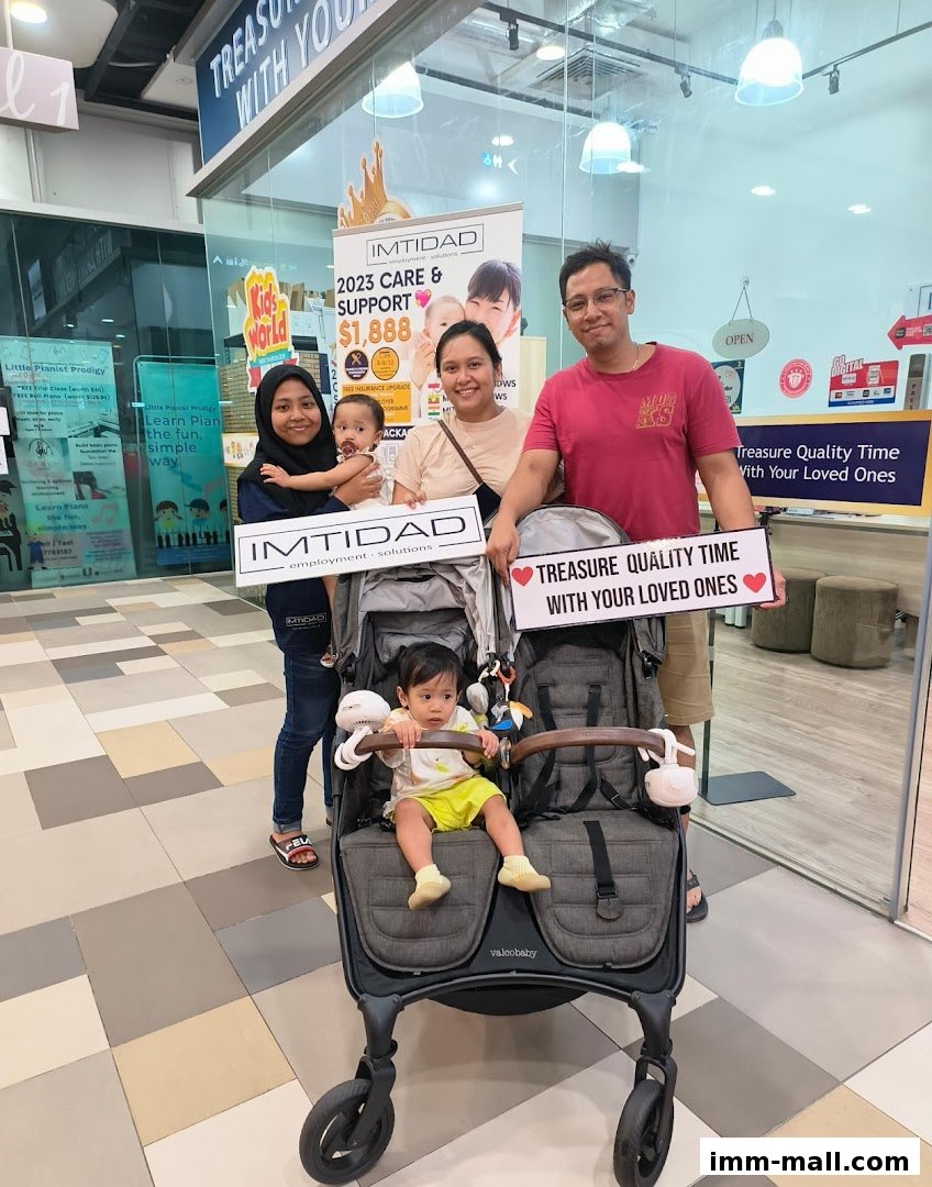 A family poses with their children in a stroller outside a shop.