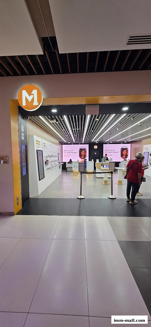 The entrance of an M1 phone shop and internet service provider with digital displays.