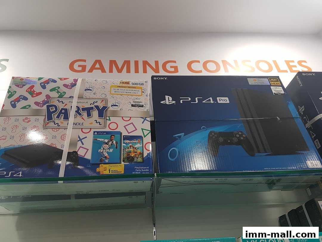 Boxes of PlayStation 4 consoles and bundles are displayed on shelves under a 'GAMING CONSOLES' sign.