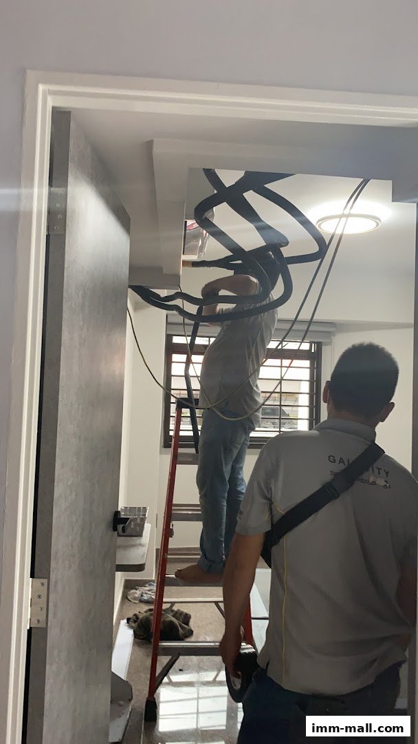 Technicians installing air conditioning units with pipes and wires.