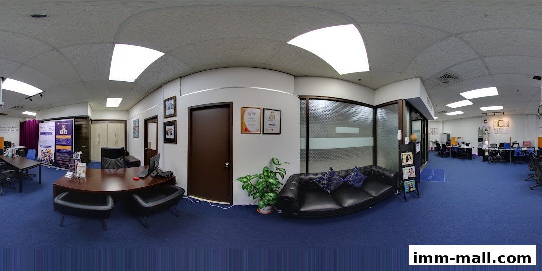 Interior view of a modern office space with desks, chairs, a reception area, and a lounge.