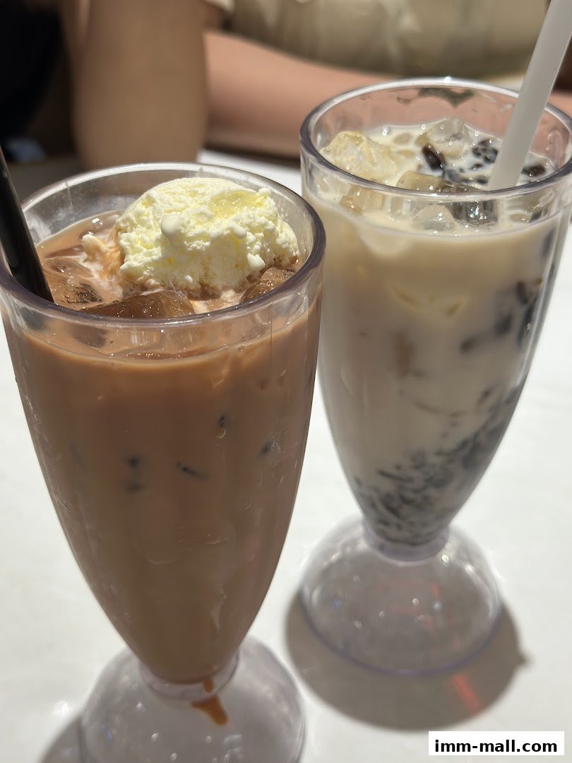 Two refreshing drinks, one with ice cream and the other with tapioca pearls, are displayed.