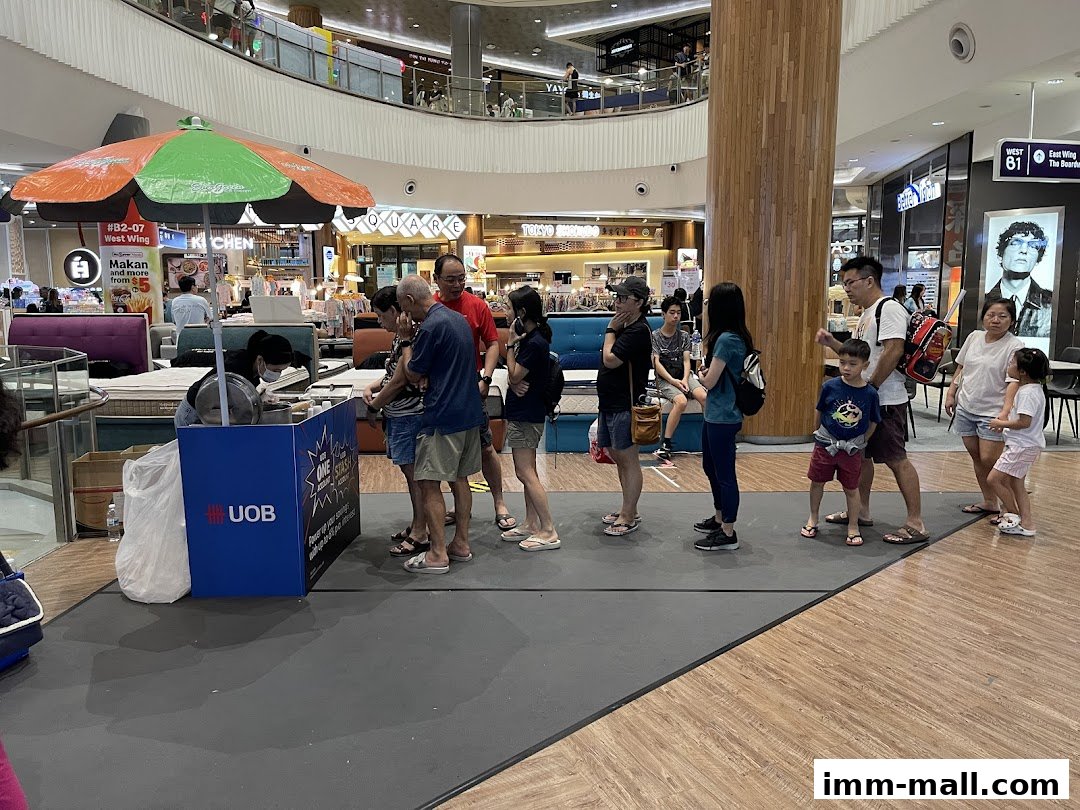 People queuing at a promotional booth in a shopping mall.
