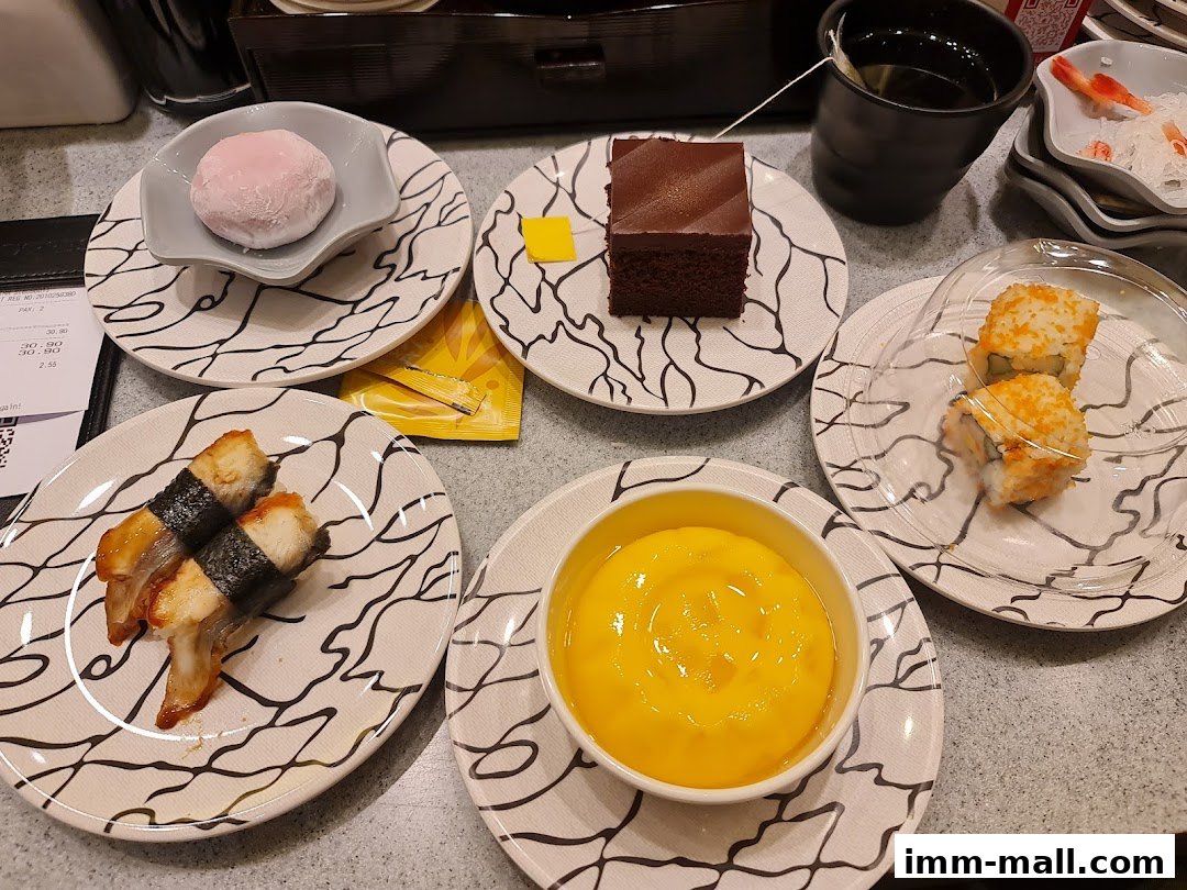 A variety of sushi, dessert, and drinks are displayed on a table at Sushi Express.
