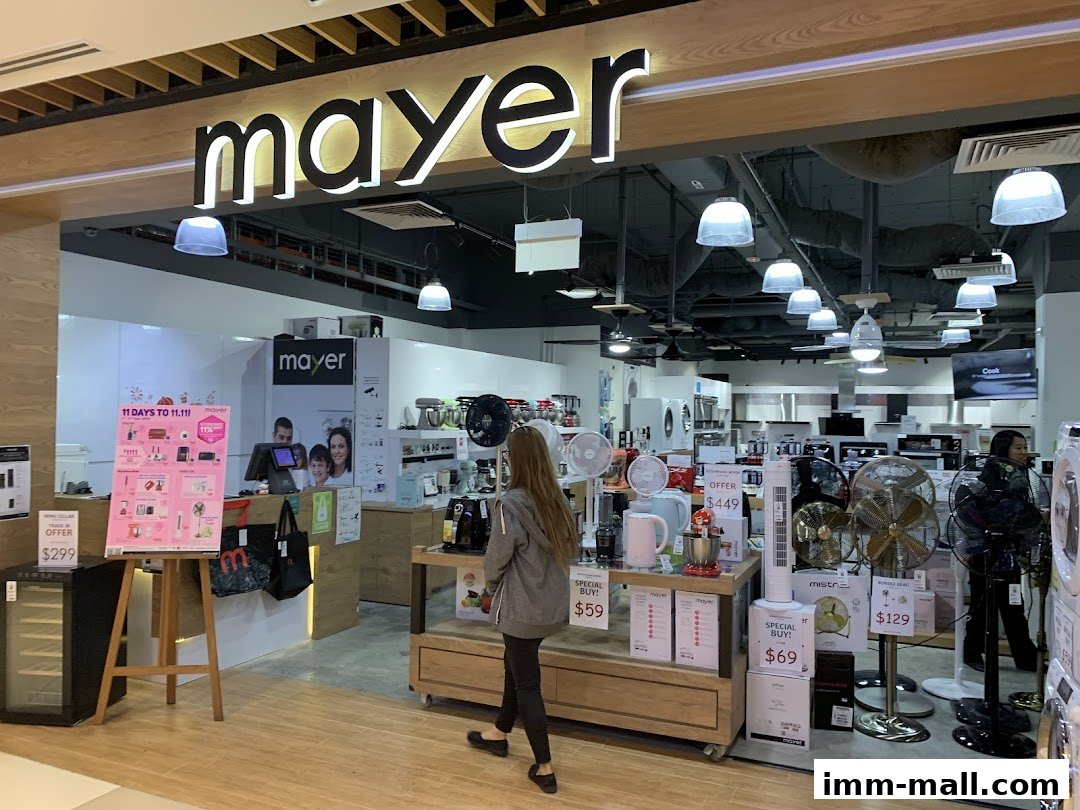 Interior view of a Mayer electronics showroom with various appliances and promotional displays.