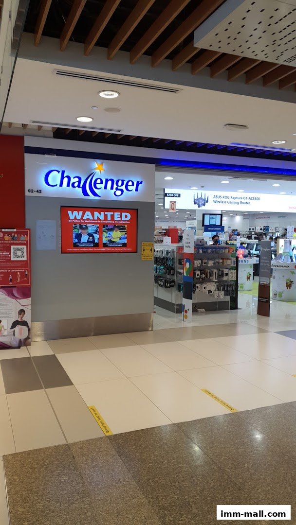 The exterior of the Challenger IMM electronics store, featuring its prominent signage and a digital display.
