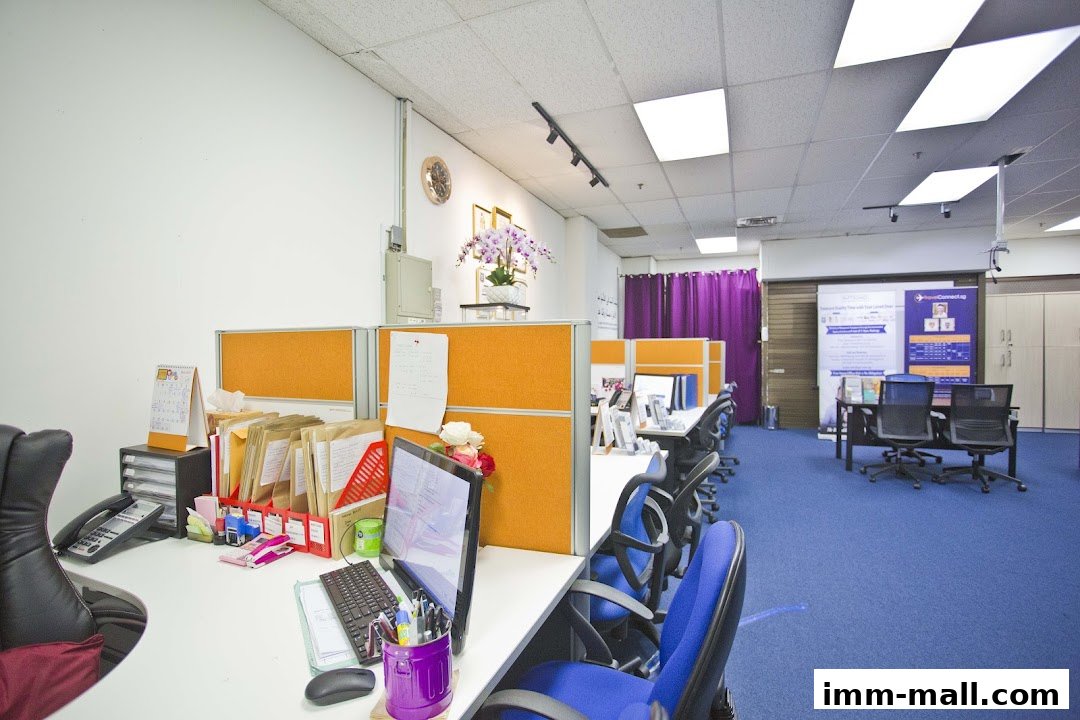 An office interior with cubicles, desks, chairs, and a calendar on a desk.