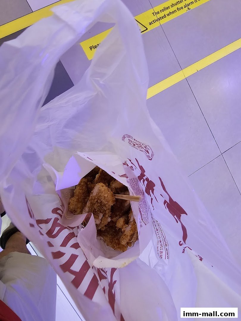 A white plastic bag from Shihlin Taiwan Street Snacks filled with crispy fried chicken.