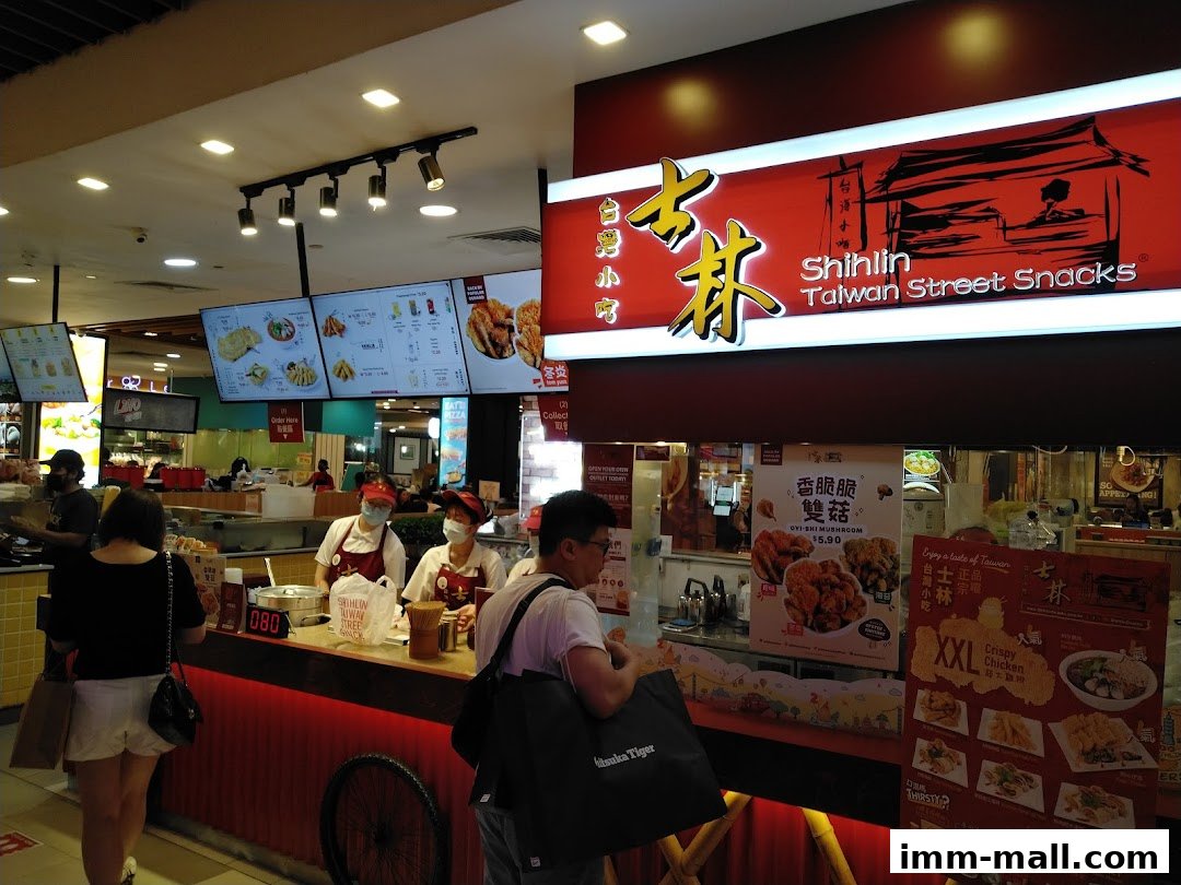 A Shihlin Taiwan Street Snacks stall with staff serving customers and digital menus displayed.