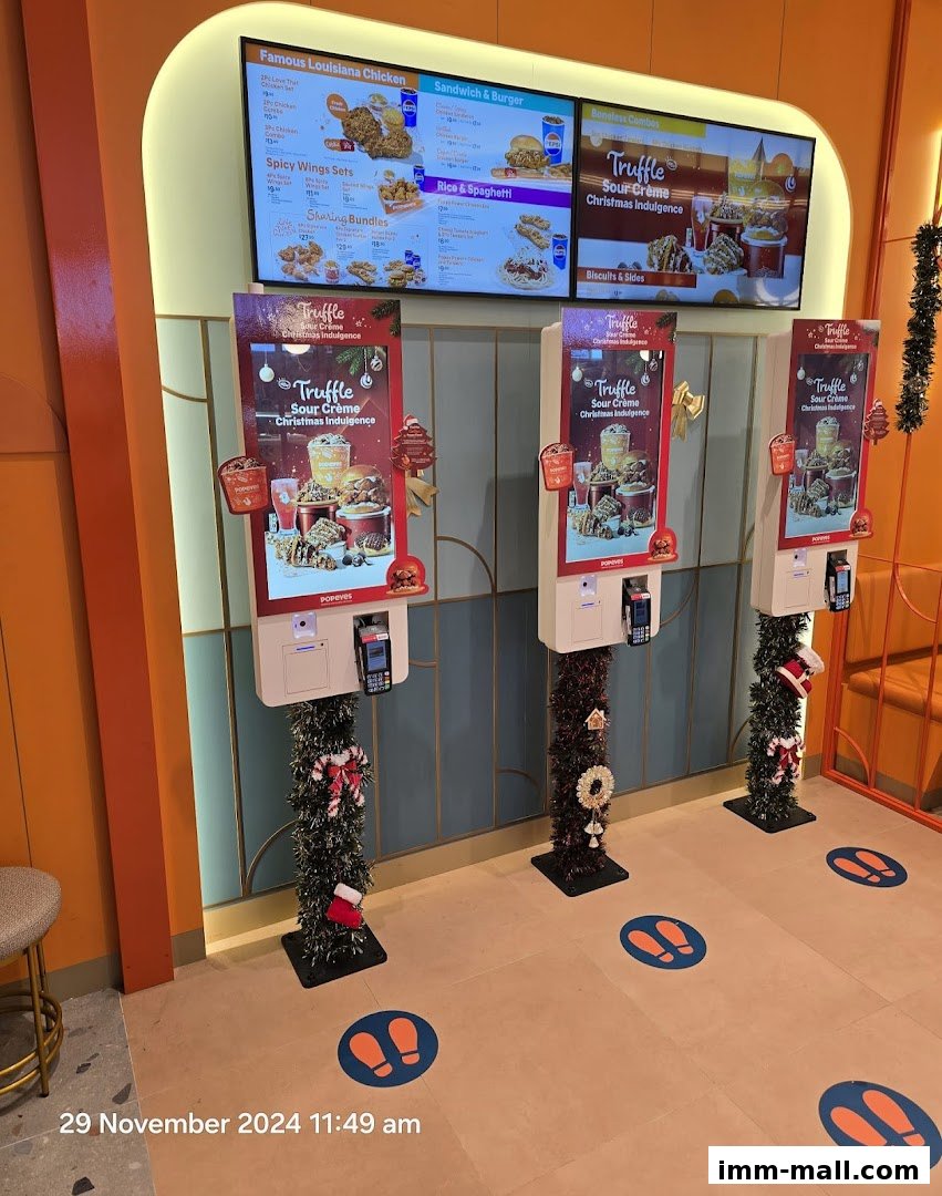 Popeyes restaurant with digital menus and ordering kiosks decorated for Christmas.