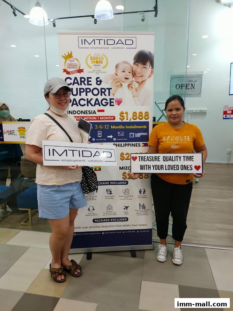 Two women holding signs for Imtidad employment solutions, promoting a care and support package.