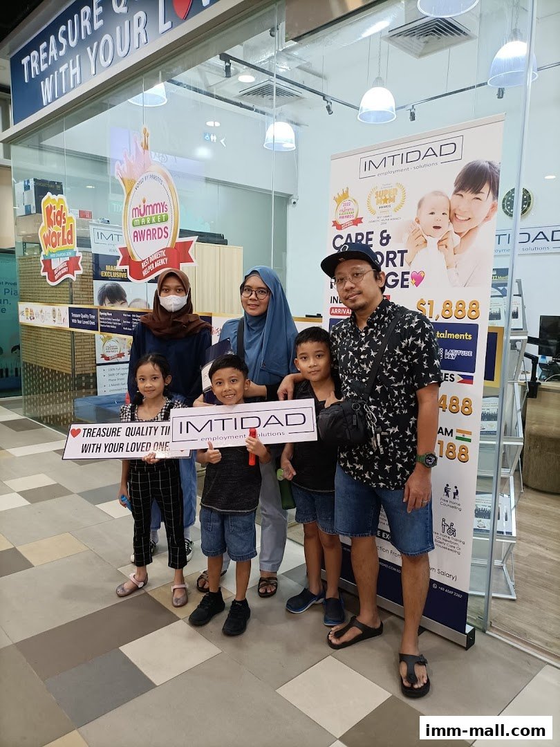 A family poses for a photo in front of a shop with promotional banners.