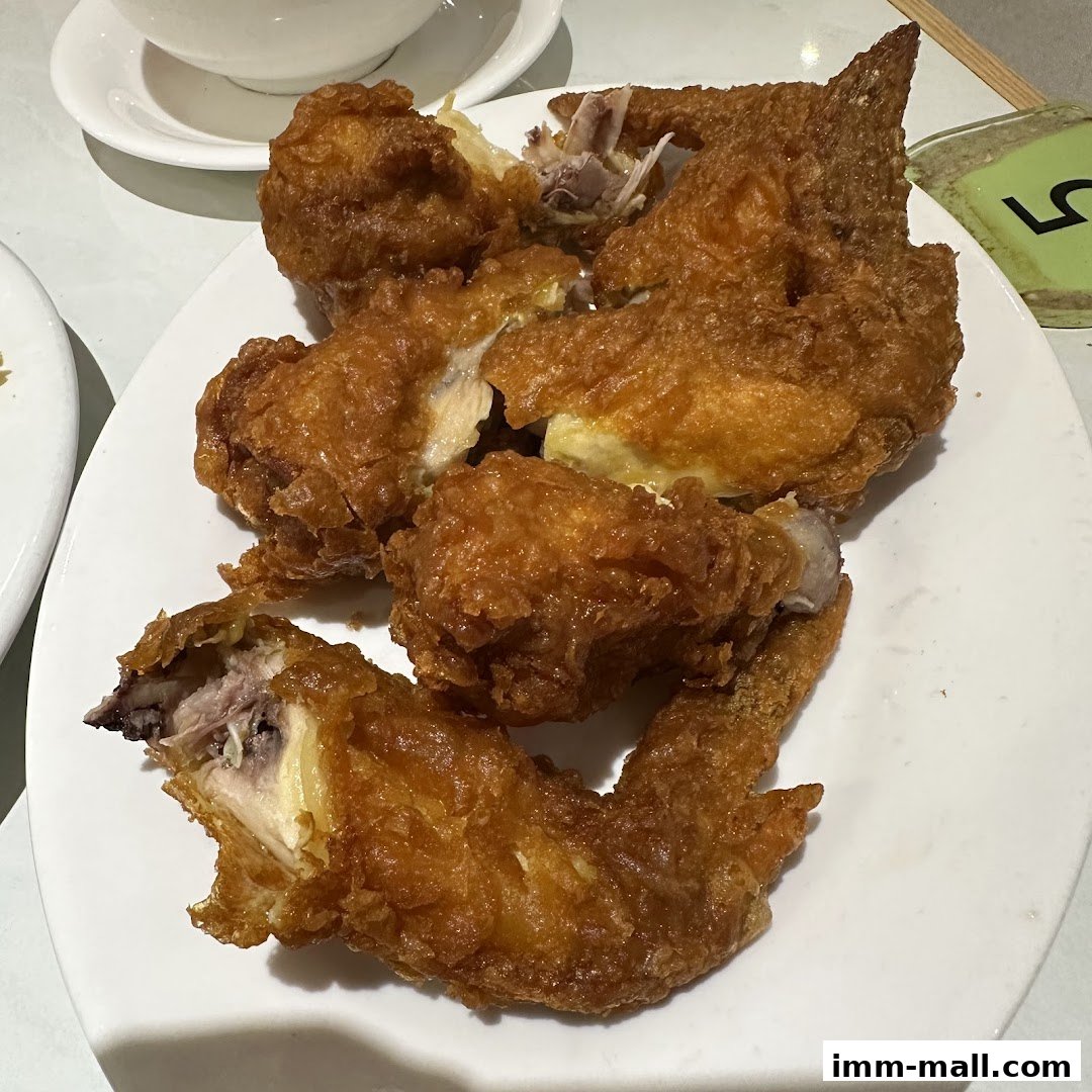 A plate of crispy, golden-brown fried chicken pieces, some with visible bones.