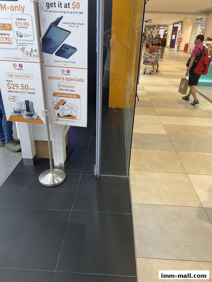 Promotional posters for M1 phone and internet services are displayed outside a shop.
