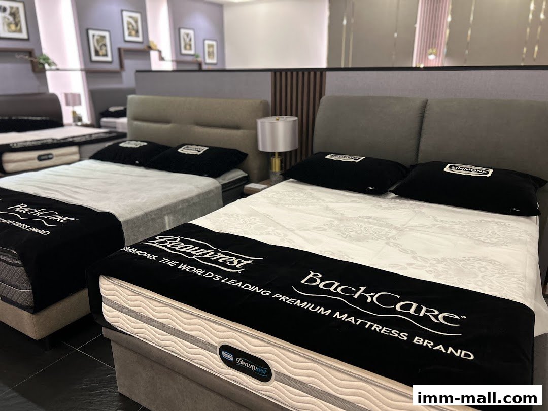 Interior view of a Simmons Gallery showroom featuring multiple beds with mattresses and pillows.
