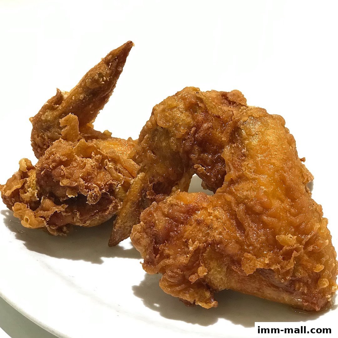 Crispy, golden-brown fried chicken wings served on a white plate.
