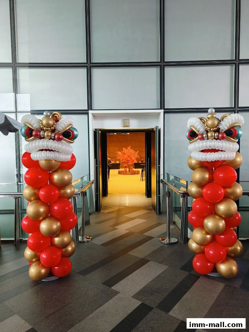 Two balloon sculptures of lion heads flank an open doorway, decorated for an event.