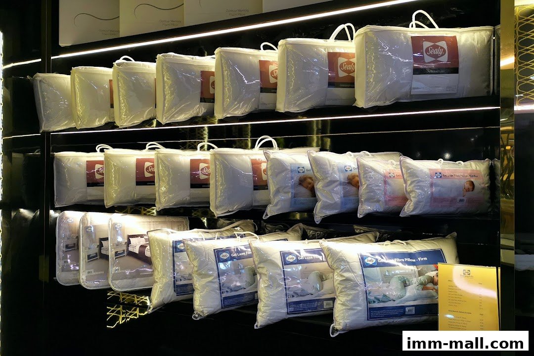 Shelves displaying various Sealy brand pillows in clear packaging.