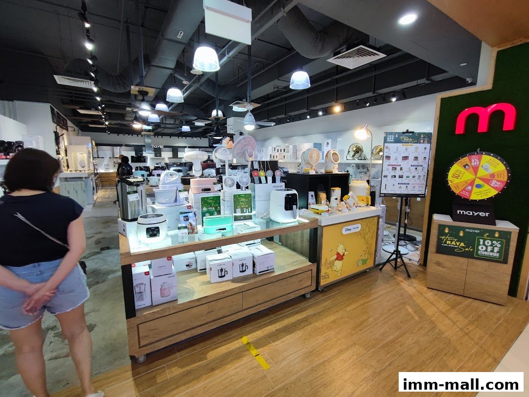 Interior view of a Mayer showroom displaying various home appliances and a promotional wheel.