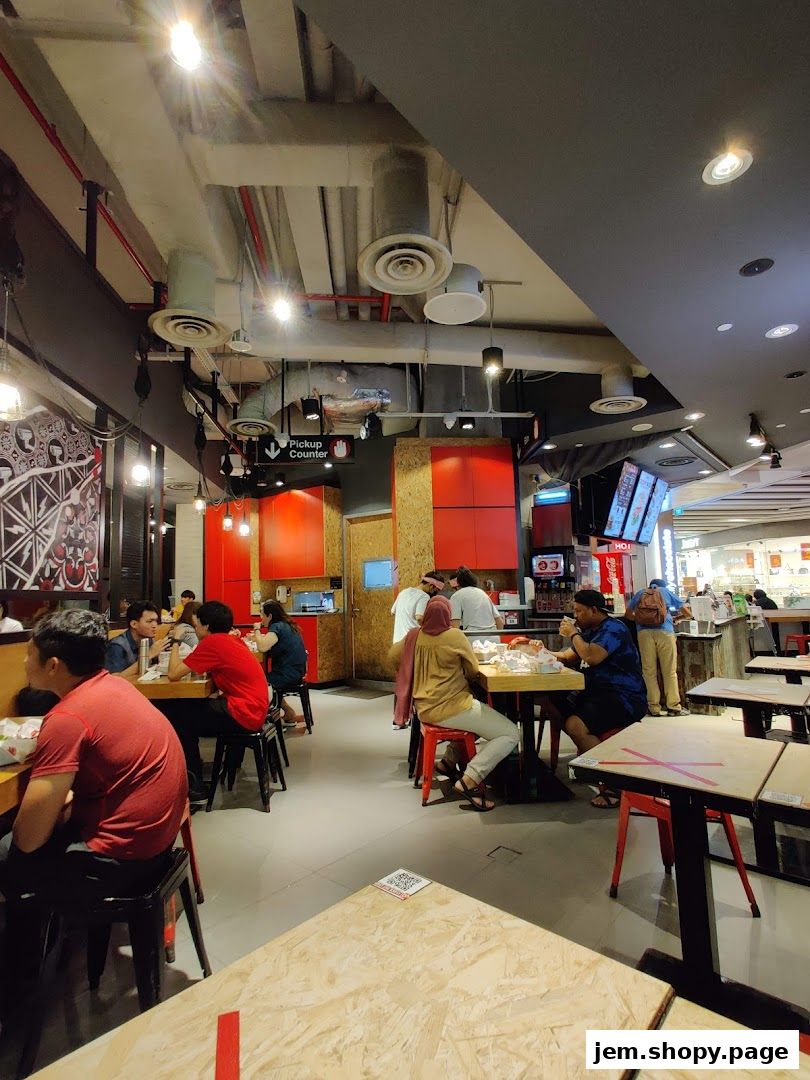Interior view of a busy 4 Fingers Crispy Chicken restaurant with diners eating.
