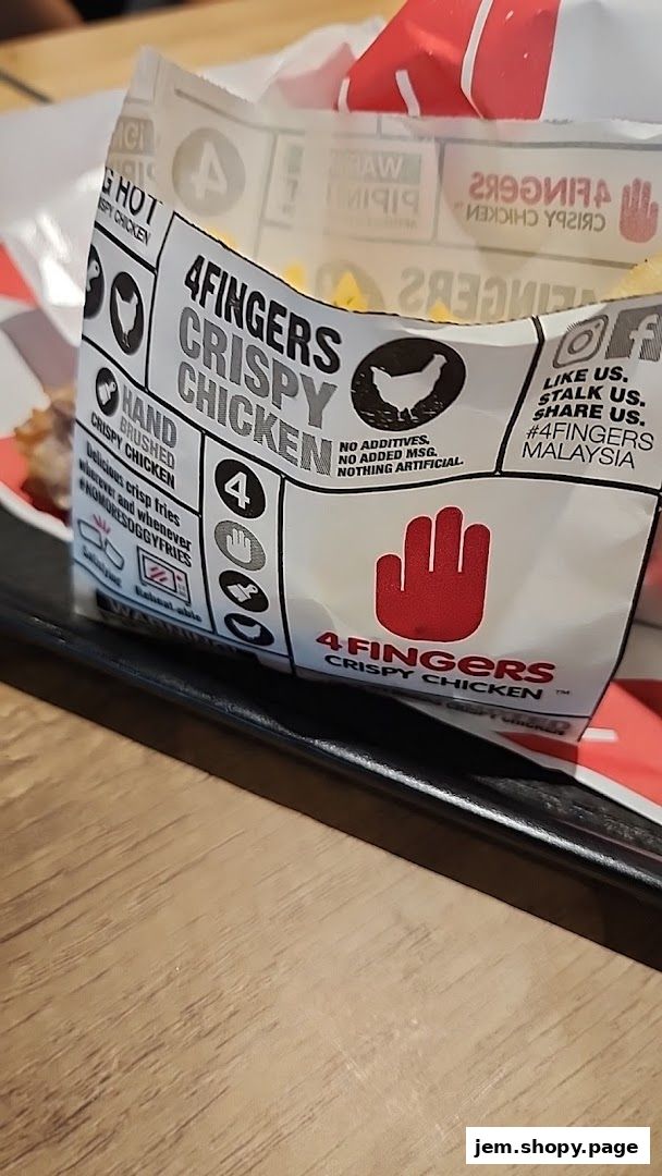 A close-up of 4 Fingers Crispy Chicken packaging with fries and chicken visible.