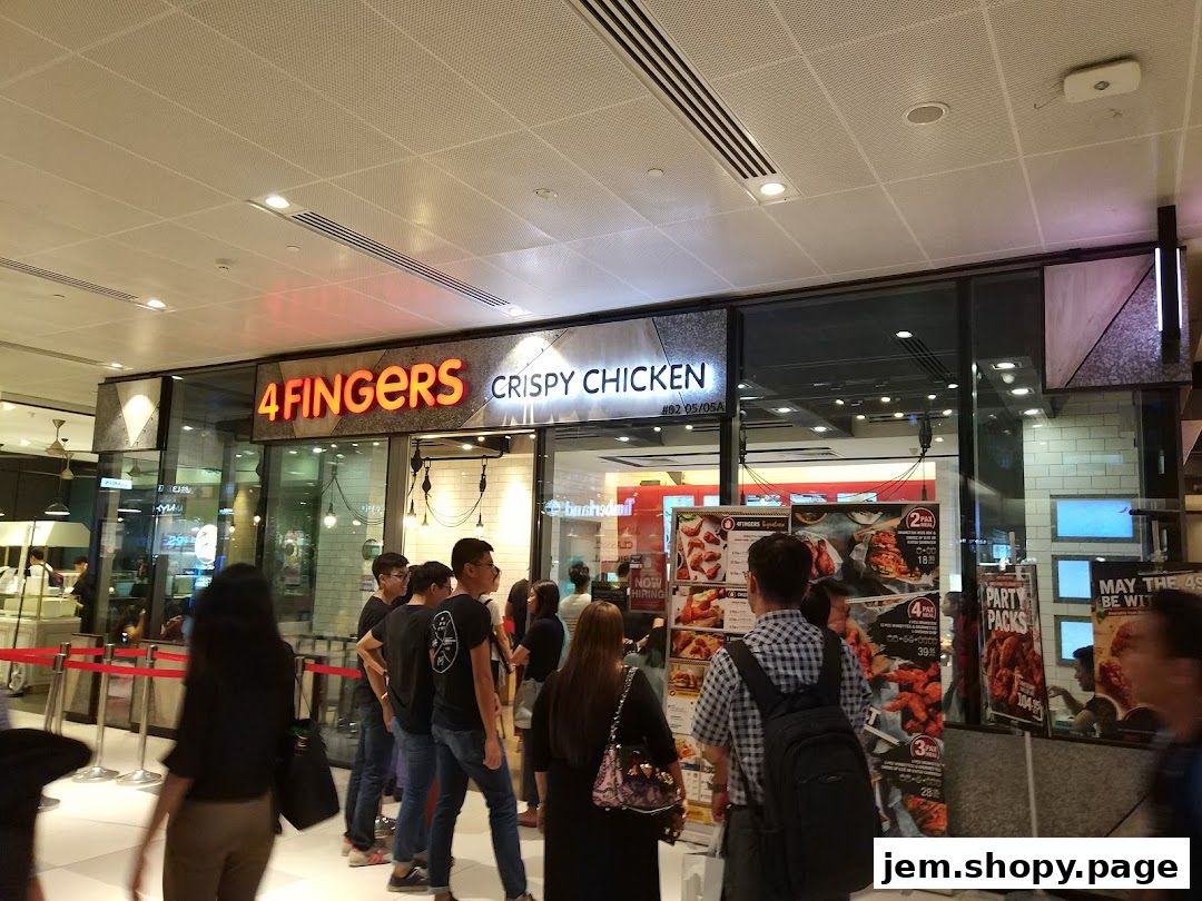 The exterior of a 4 Fingers Crispy Chicken shop with customers queuing.