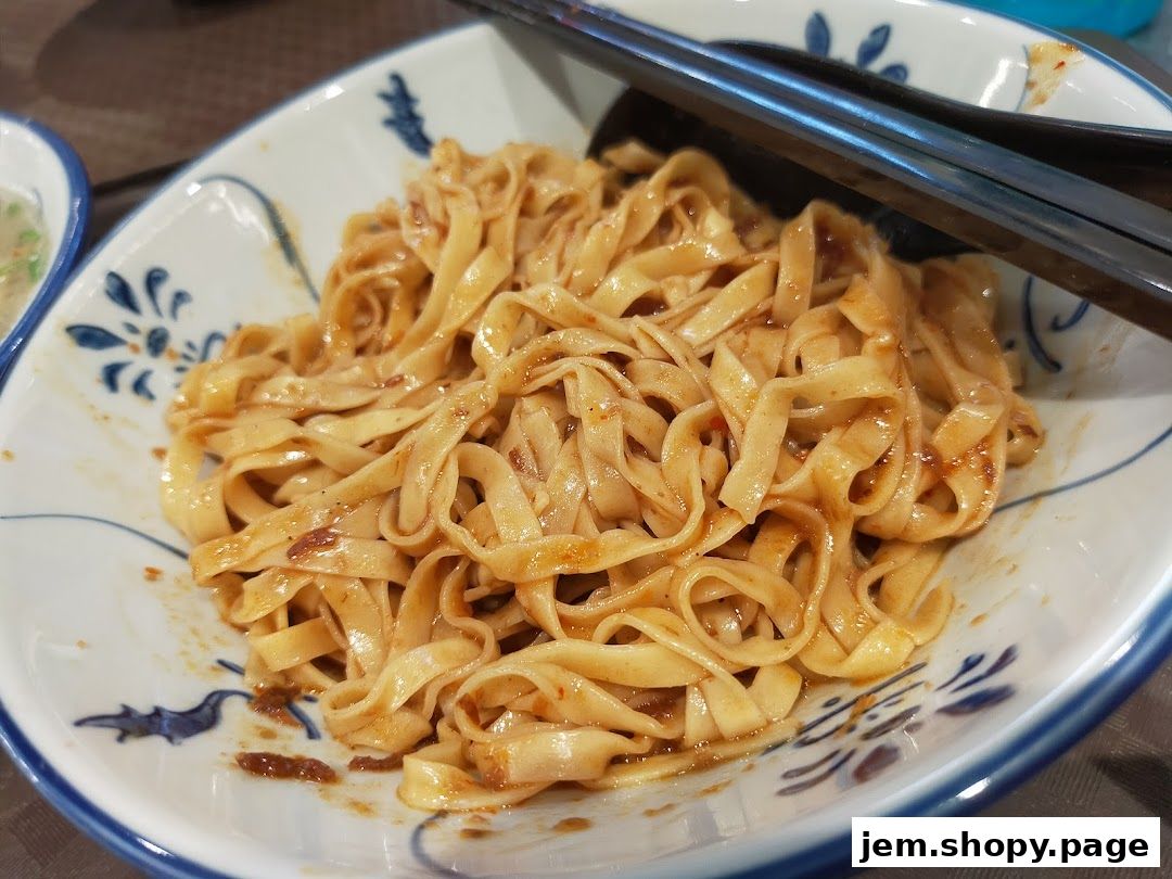A close-up shot of a bowl of delicious noodles with chopsticks resting on top.