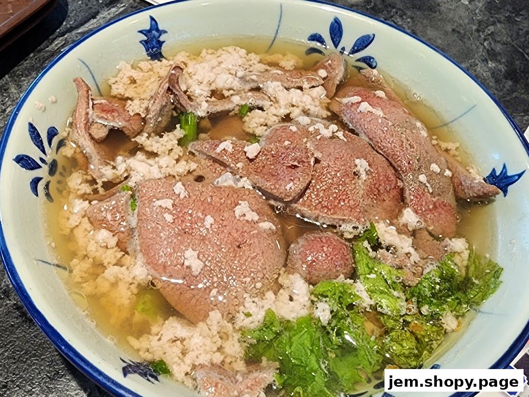 A close-up shot of a delicious bowl of noodle soup with liver and minced pork.