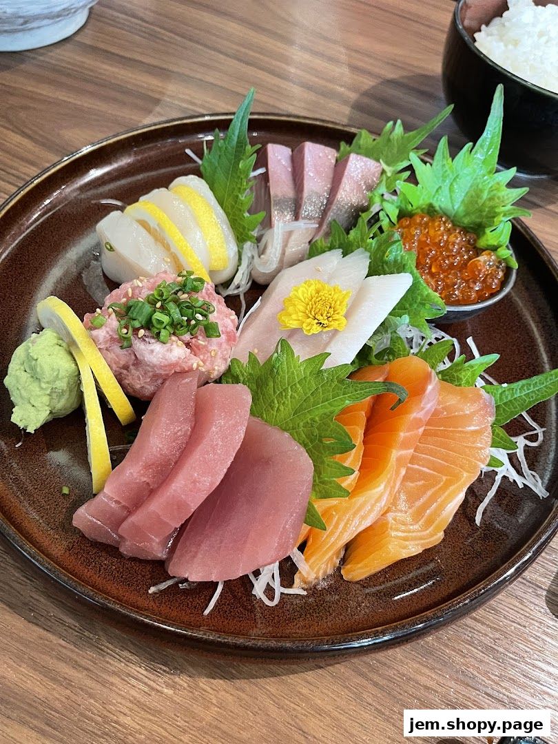 A beautifully arranged platter of assorted sashimi, including salmon, tuna, and scallop, with ikura and wasabi.