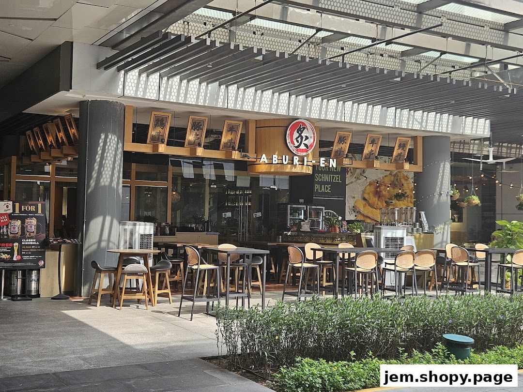 The exterior of Aburi-EN Jem restaurant with outdoor seating and a prominent sign.