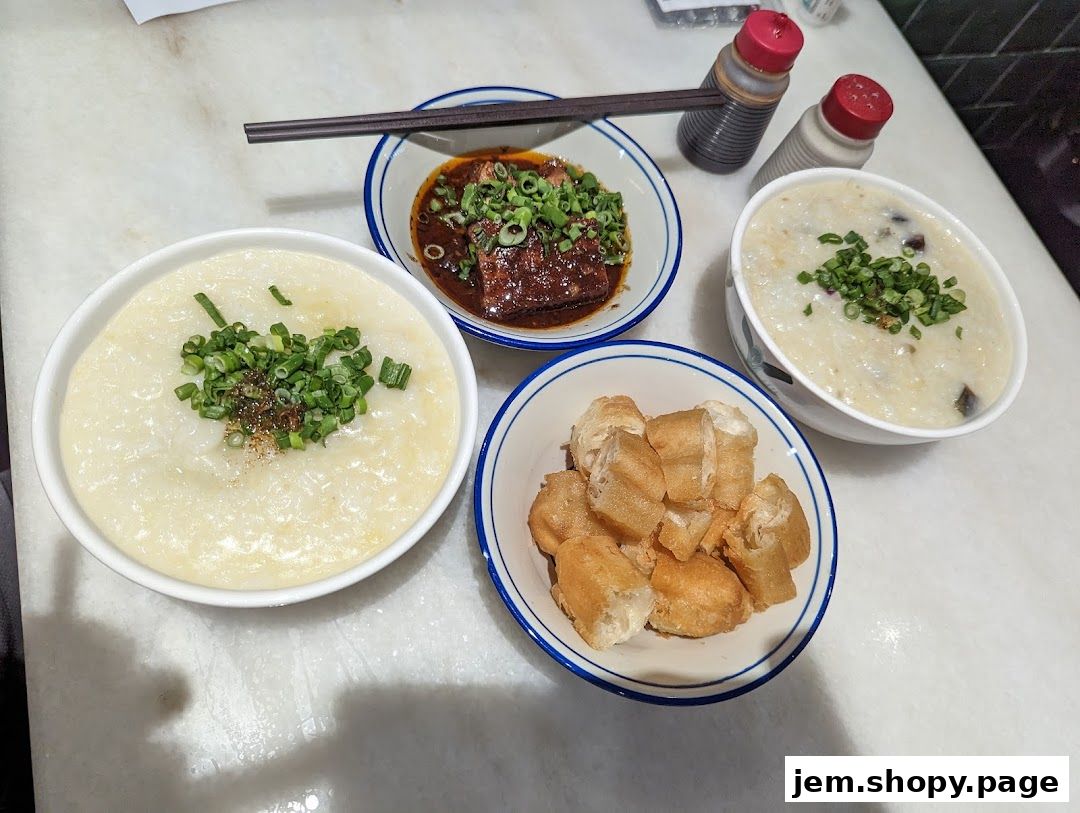 A spread of traditional porridge dishes with fried dough sticks and condiments.
