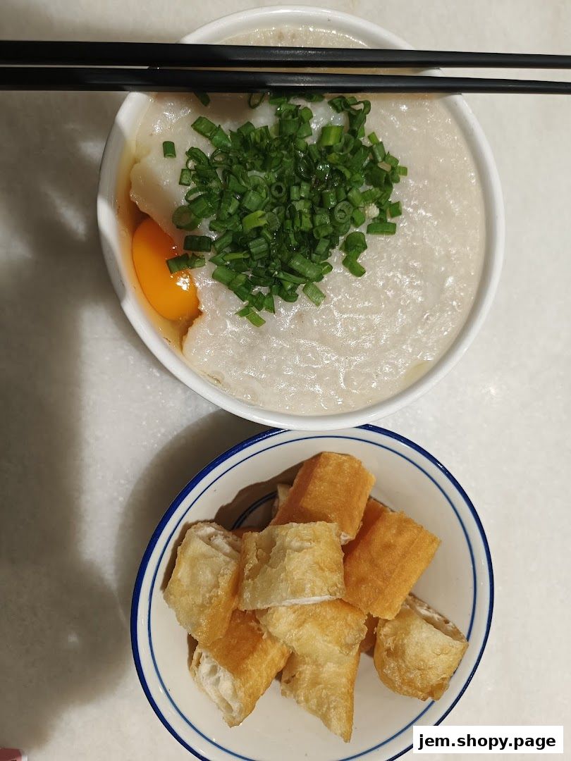 A bowl of porridge with an egg and chives, served with fried dough sticks.