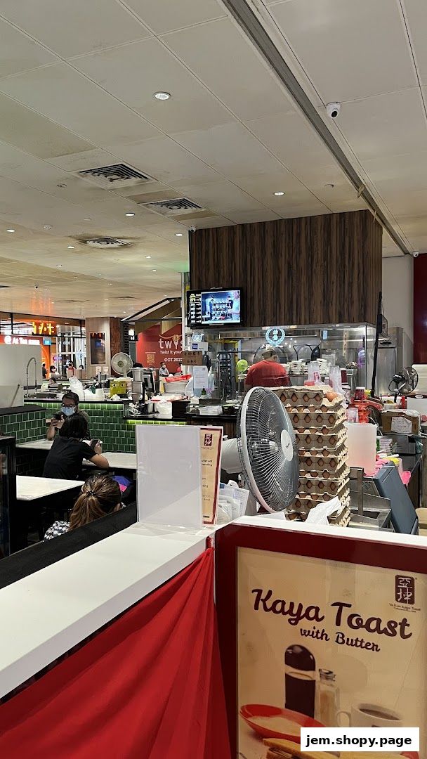 Interior view of Ah Chiangs Traditional Porridge shop with customers and food preparation area.