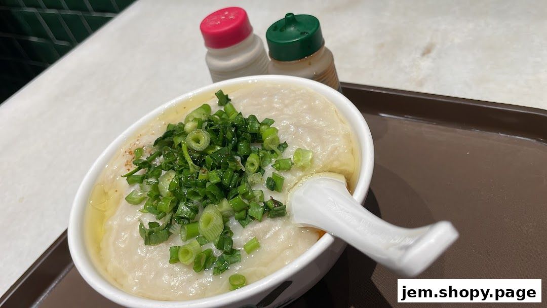 A bowl of traditional porridge topped with chopped green onions and a spoon.
