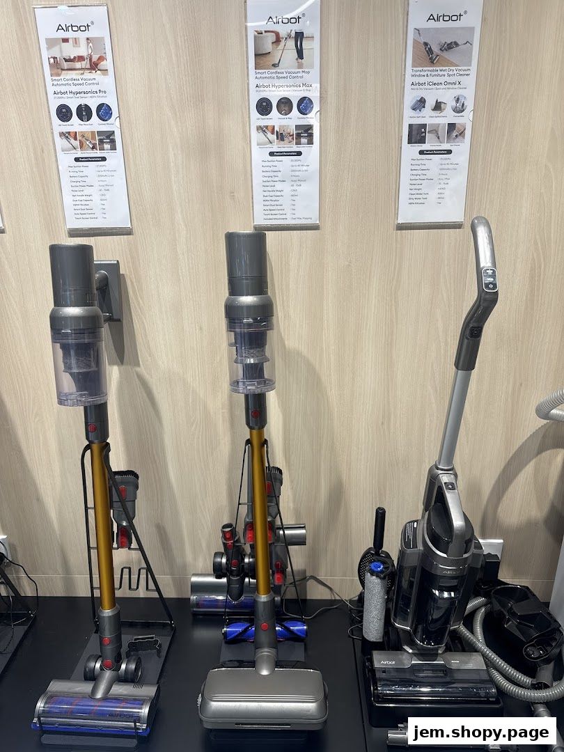 Three Airbot vacuum cleaners are displayed on a black surface with product information posters behind them.