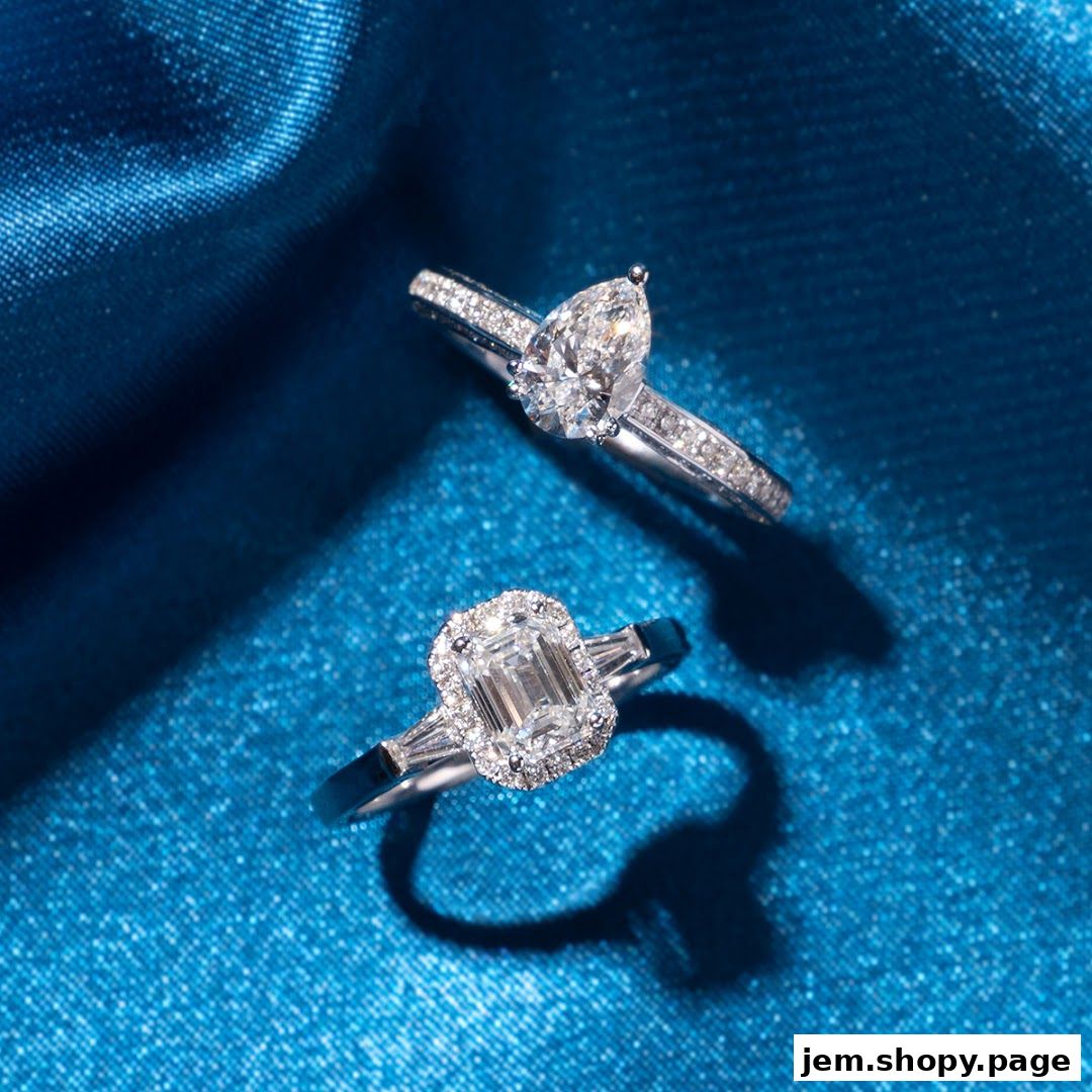 Two exquisite diamond engagement rings displayed on a shimmering blue satin background.