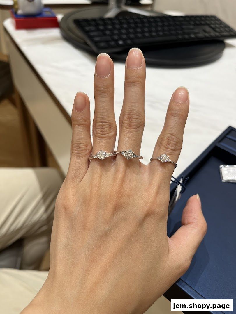 A hand wearing three diamond engagement rings, showcasing exquisite craftsmanship.